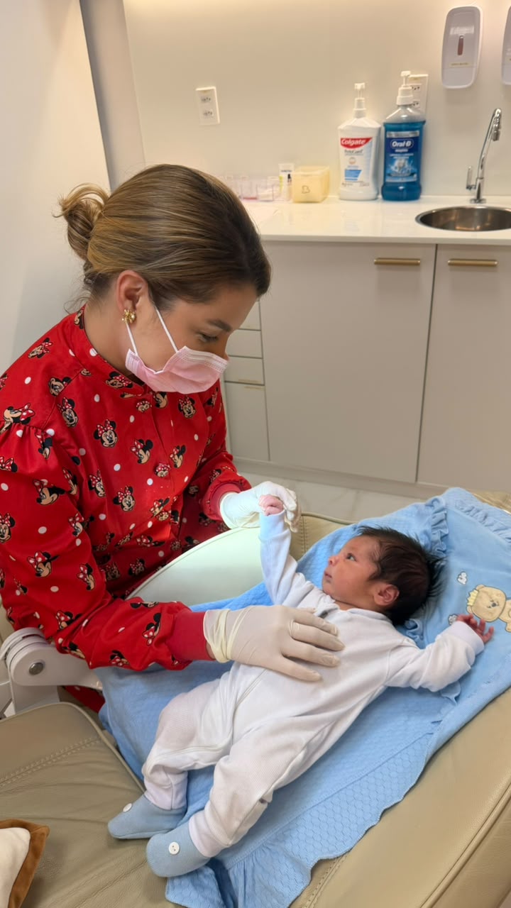 Dra. Thirza Nunes cuidando de um recém-nascido na cadeira odontológica